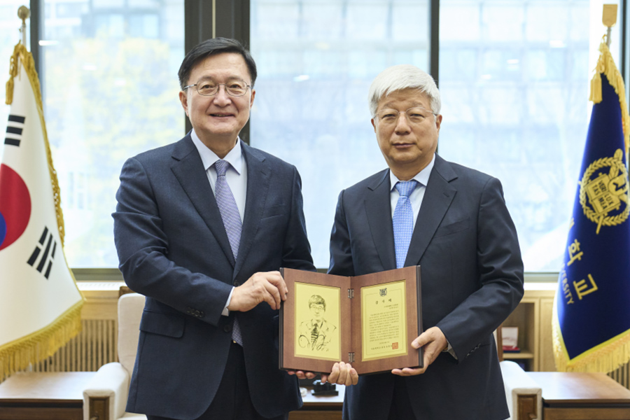 유홍림 총장과 유한상 교수가 감사패 전달 후 기념 촬영을 하고 있다.